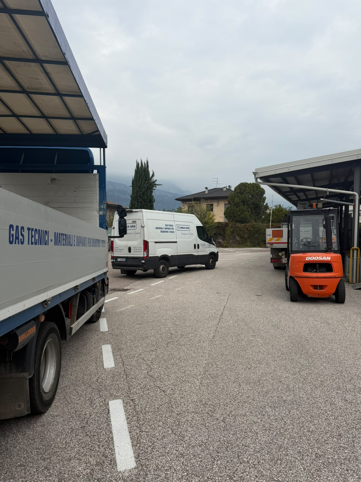 Piazzale Linea Gas con il furgone aziendale, l'autocarro per il trasporto di gas tecnici e il carrello elevatore accanto alla tettoia
